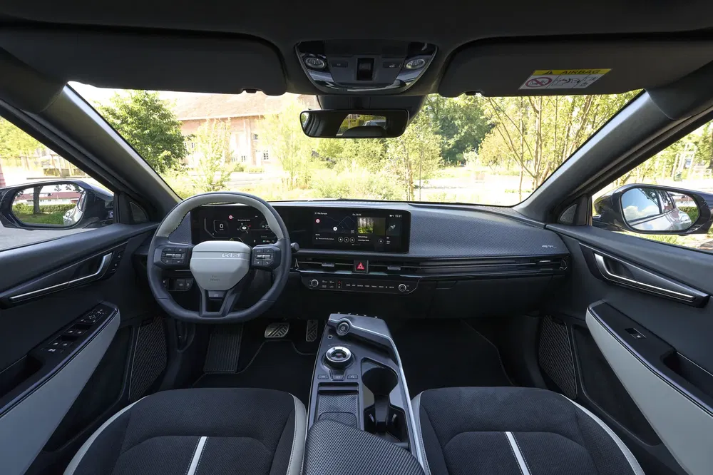 Moderne interieur van een Kia EV6 met digitaal dashboard en centraal touchscreen.