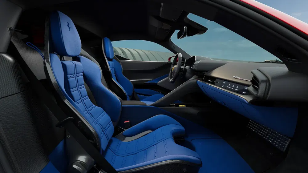 Intérieur d'une Ferrari avec sièges en cuir bleu et tableau de bord moderne.