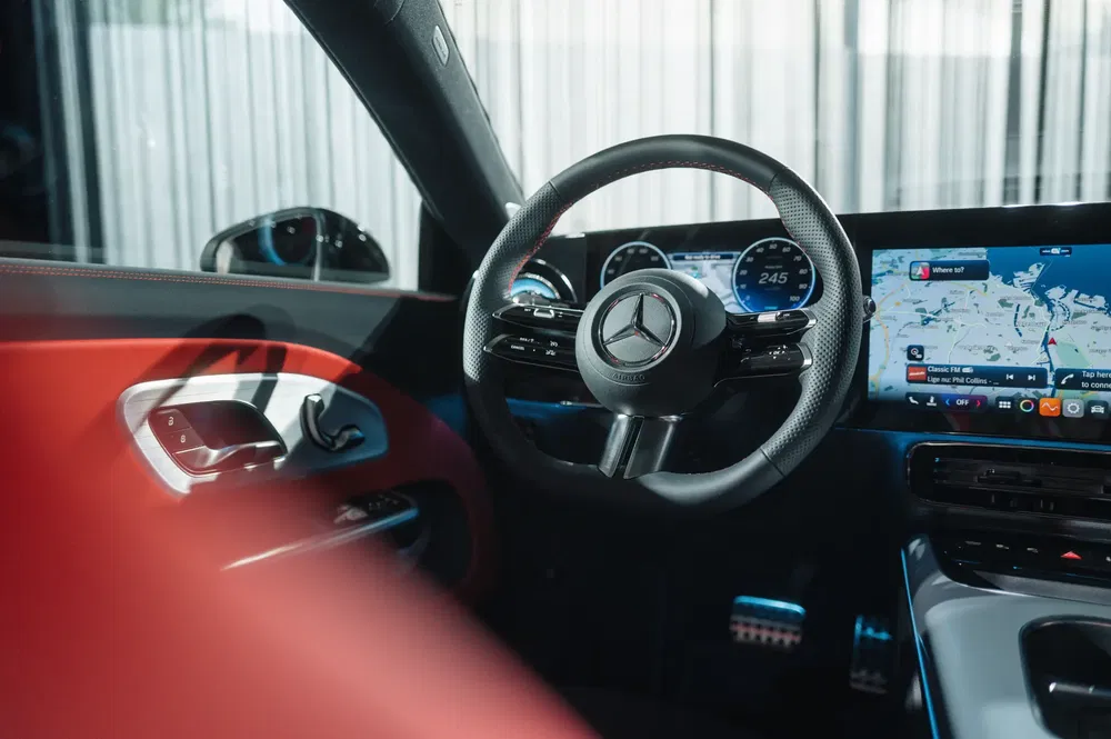 Intérieur de voiture de luxe Mercedes avec volant en cuir et écran de navigation high-tech.