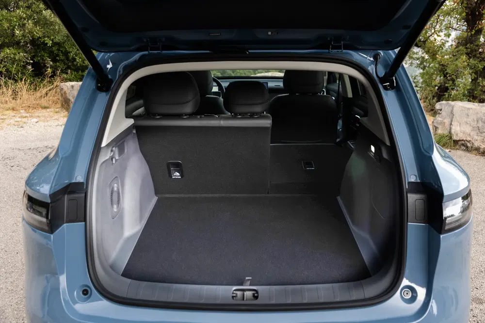 Coffre spacieux d'une Opel Astra 2023, hayon ouvert, intérieur moderne et élégant.
