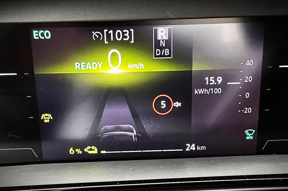 Digitaal dashboard van een elektrische auto toont verbruiks- en snelheidsgegevens.