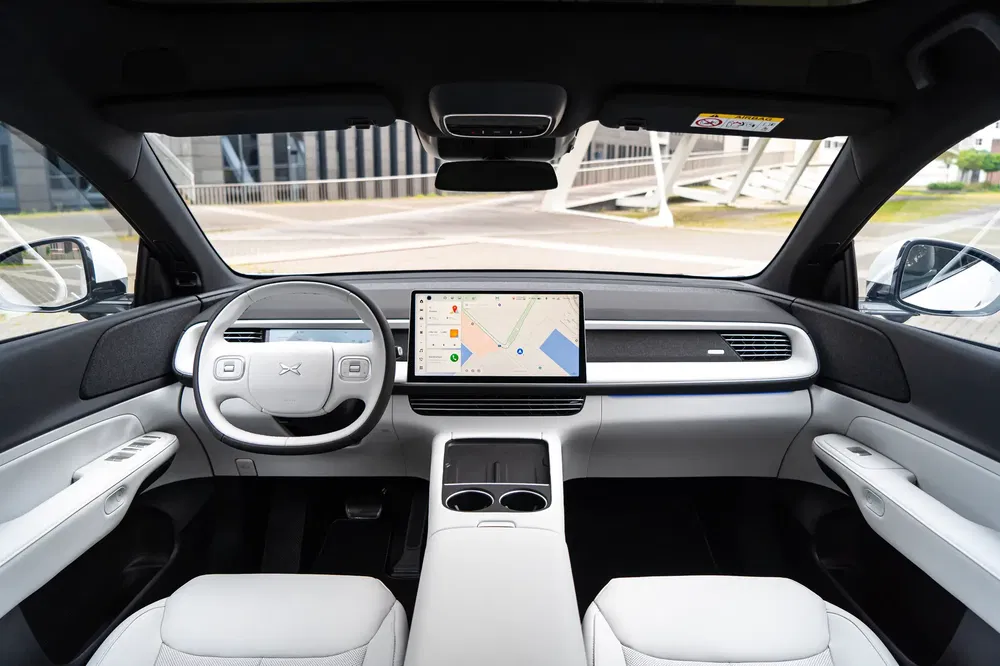Intérieur moderne de voiture électrique XPeng P7 avec écran tactile central et volant minimaliste.