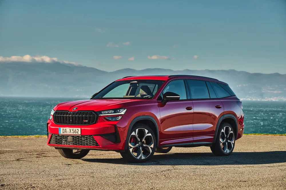 SUV Škoda Kodiaq rouge stationné devant une vue maritime panoramique.