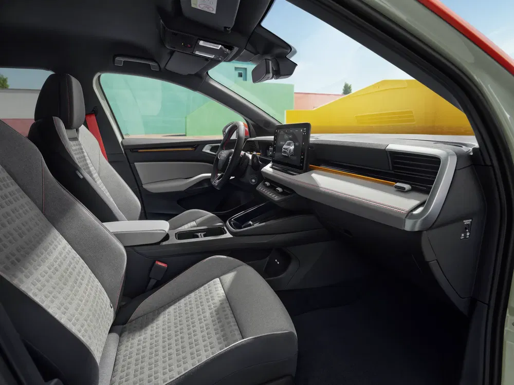 Intérieur spacieux d'une voiture moderne avec écran tactile central et sièges confortables.