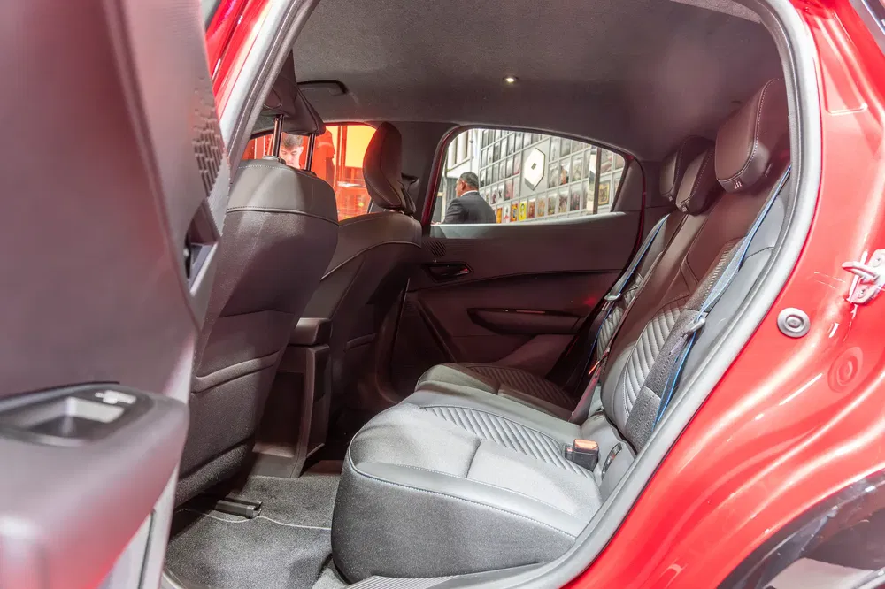 Ruim interieur van een compacte rode auto, comfortabele en goed gevoerde achterstoelen.