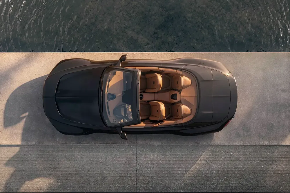 Vue aérienne d'une cabriolet élégante stationnée près d'un plan d'eau, intérieur beige luxueux.