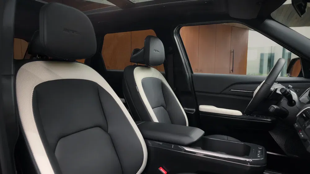 Intérieur luxueux d'un SUV avec sièges en cuir noir et blanc, tableau de bord moderne.