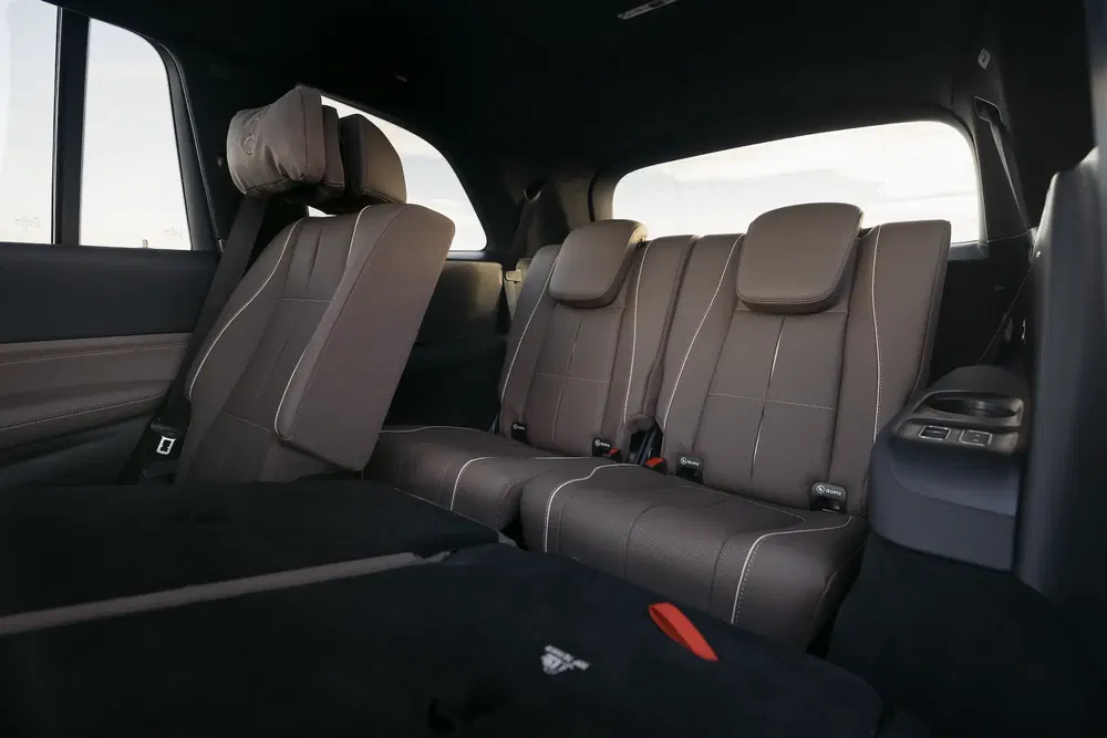 Intérieur spacieux d'un SUV moderne avec sièges rabattables et appuie-tête en cuir marron.