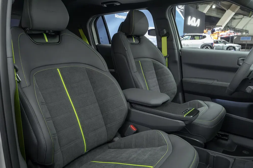 Intérieur de voiture Kia avec sièges en cuir noir et détails verts lumineux.