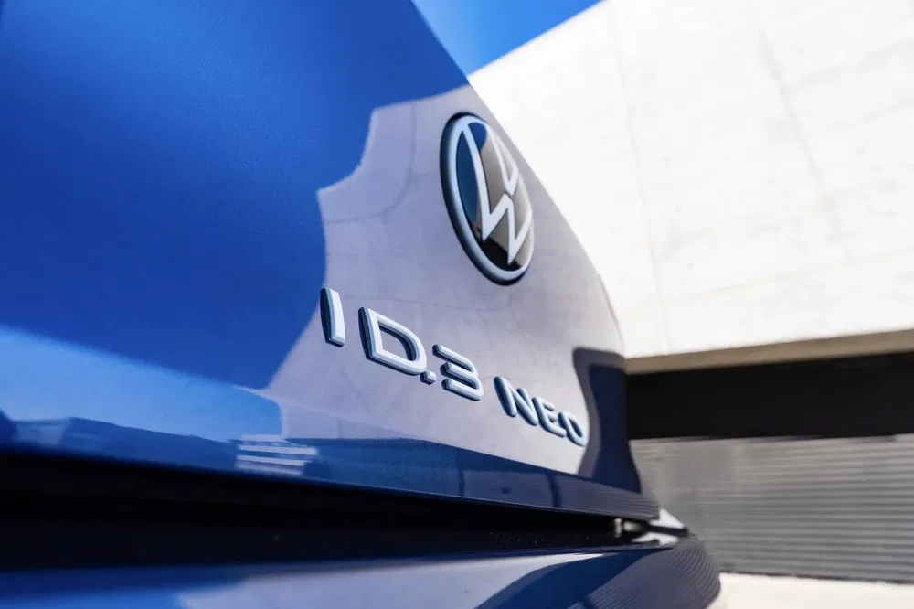 {"fr":"Détail du badge arrière Volkswagen ID.3 Neo bleu avec logo VW visible.","nl":"Close-up van blauwe Volkswagen ID.3 Neo achterembleem met zichtbare VW-logo."}