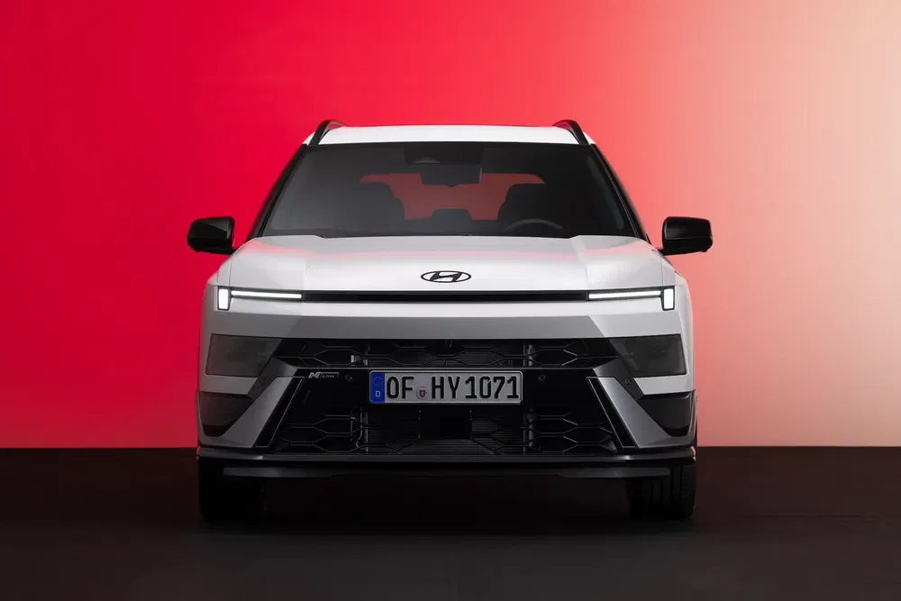 Hyundai SUV blanc de face, fond dégradé rouge et noir, design moderne et audacieux.
