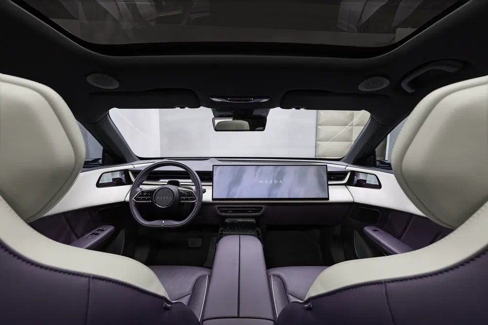 Intérieur moderne Mazda avec écran large et volant élégant, design luxueux et épuré.