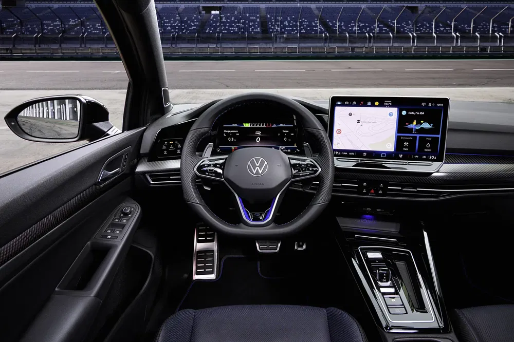 Interieur van de Volkswagen Golf met touchscreen en moderne stuur op een circuit.