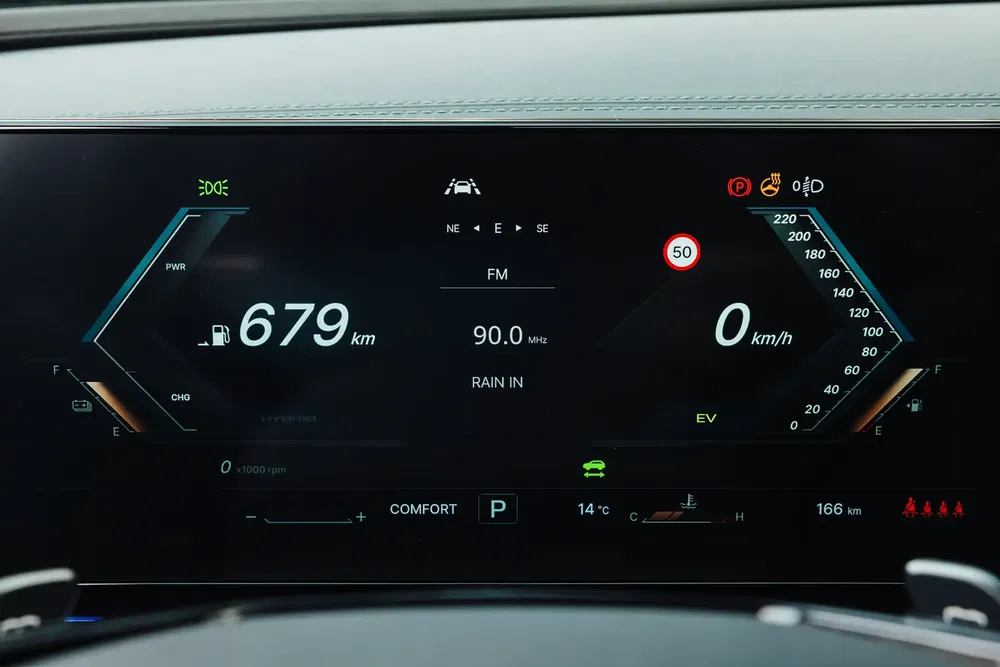 Digitaal dashboard toont resterend bereik en snelheid in een moderne auto.