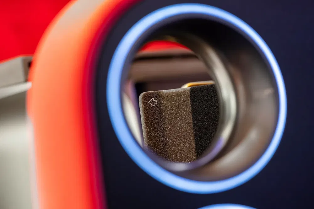 Vue rapprochée d'une poignée de portière intérieure avec un accent lumineux circulaire bleu.