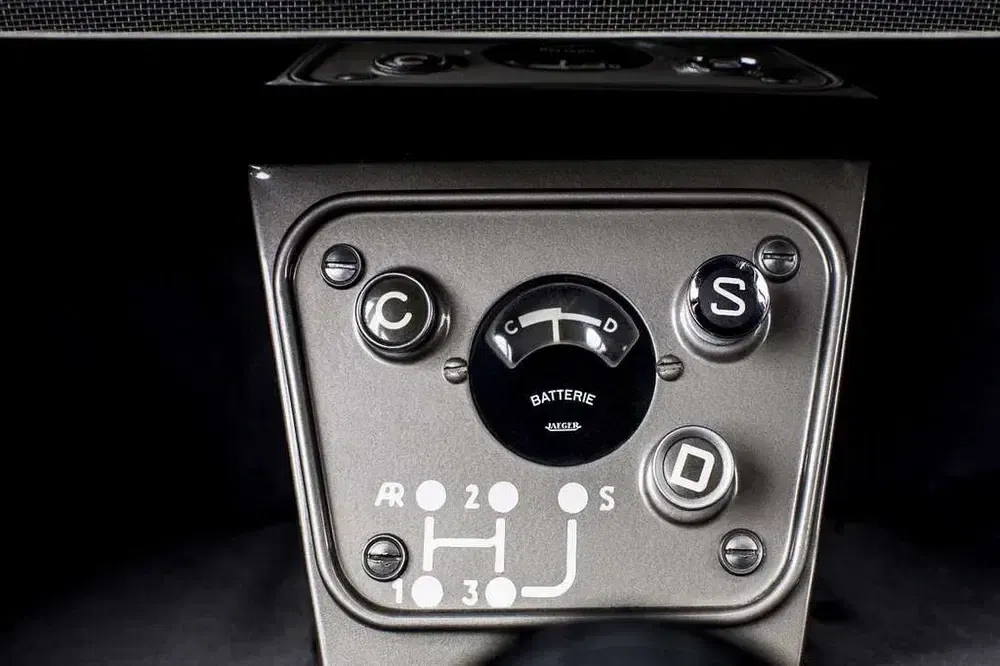 Panneau de contrôle rétro de voiture avec indicateur de batterie et leviers de vitesse distinctifs.