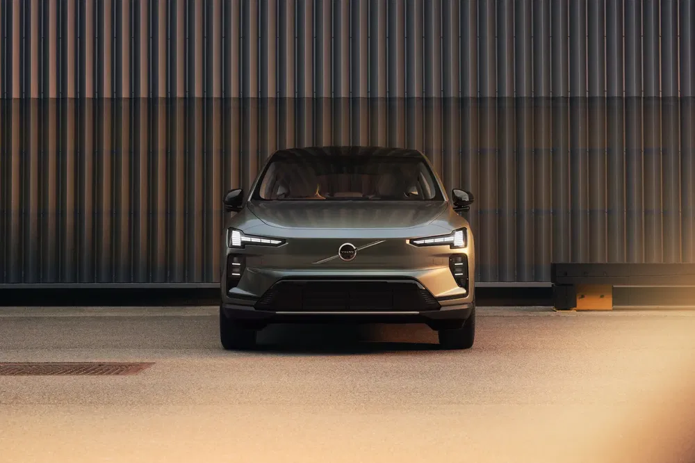 Voiture Volvo moderne stationnée devant un mur, phares LED distincts allumés.