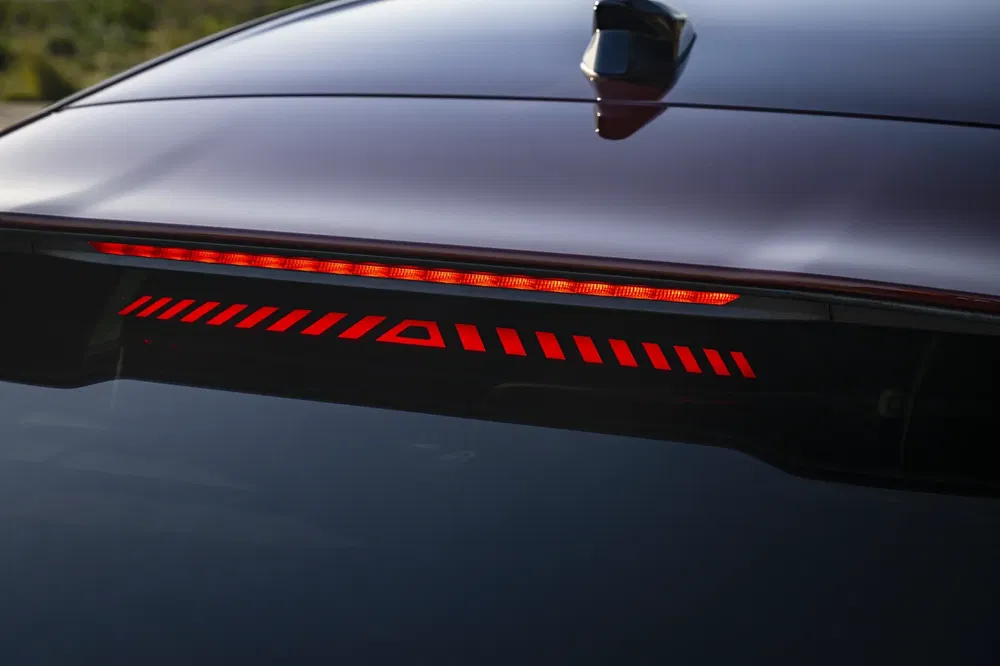 Feu arrière high-tech d'une voiture électrique moderne avec design LED dynamique rouge.