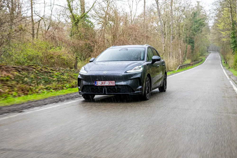 Voiture MG roulant sur une route forestière mouillée par temps de pluie.