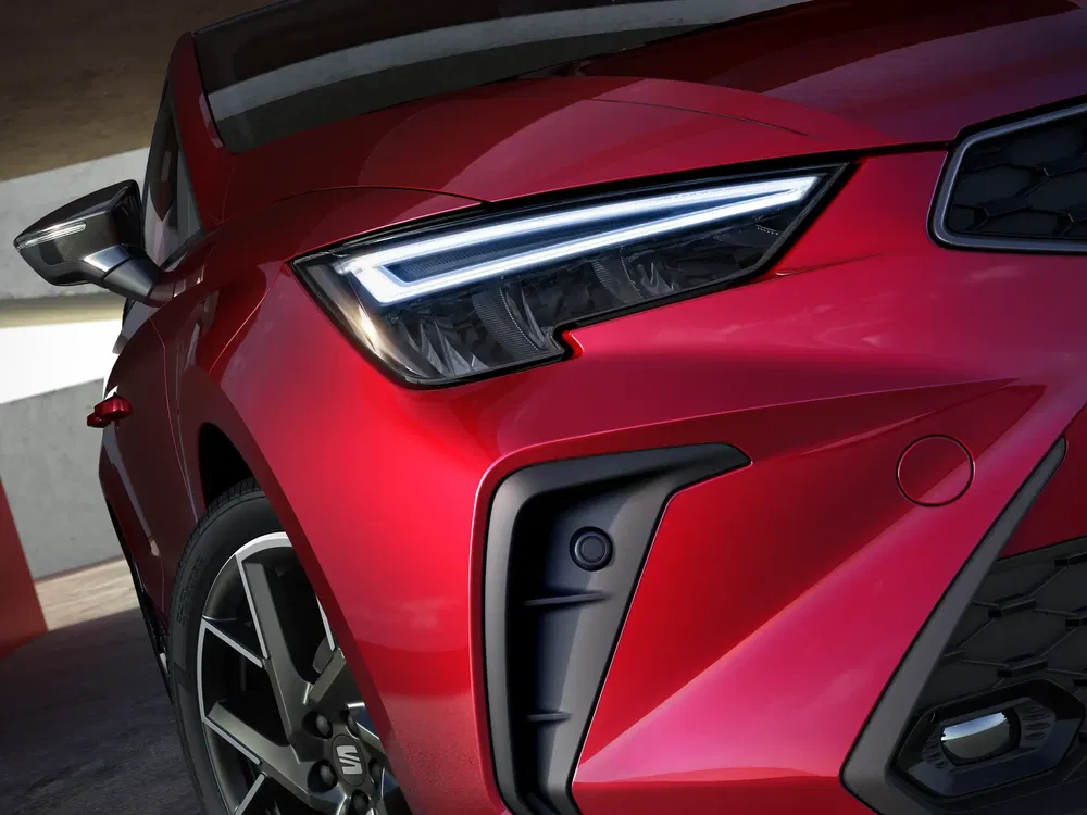 Close-up van een rode SEAT Leon koplamp met een hoekig en modern ontwerp.