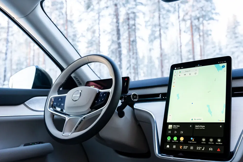 Intérieur de voiture Volvo, tableau de bord moderne avec écran tactile GPS, volant élégant.