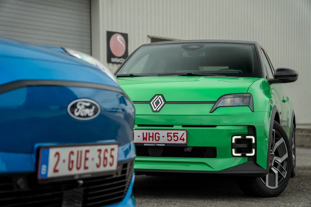 Renault R5 elektrisch en Ford concurreren op een modern parkeerterrein.