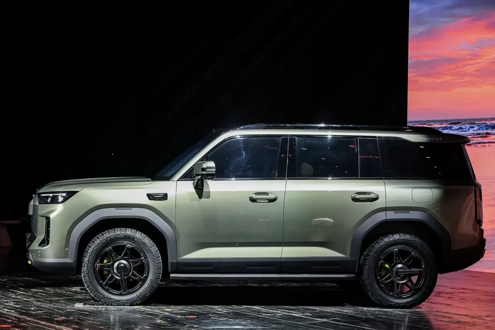 SUV moderne Chery Explorer brun sur scène avec décoration plage en arrière-plan.