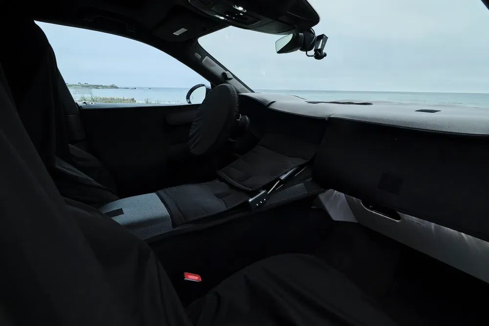 Intérieur d'une voiture avec camouflages, vue sur l'océan en arrière-plan.