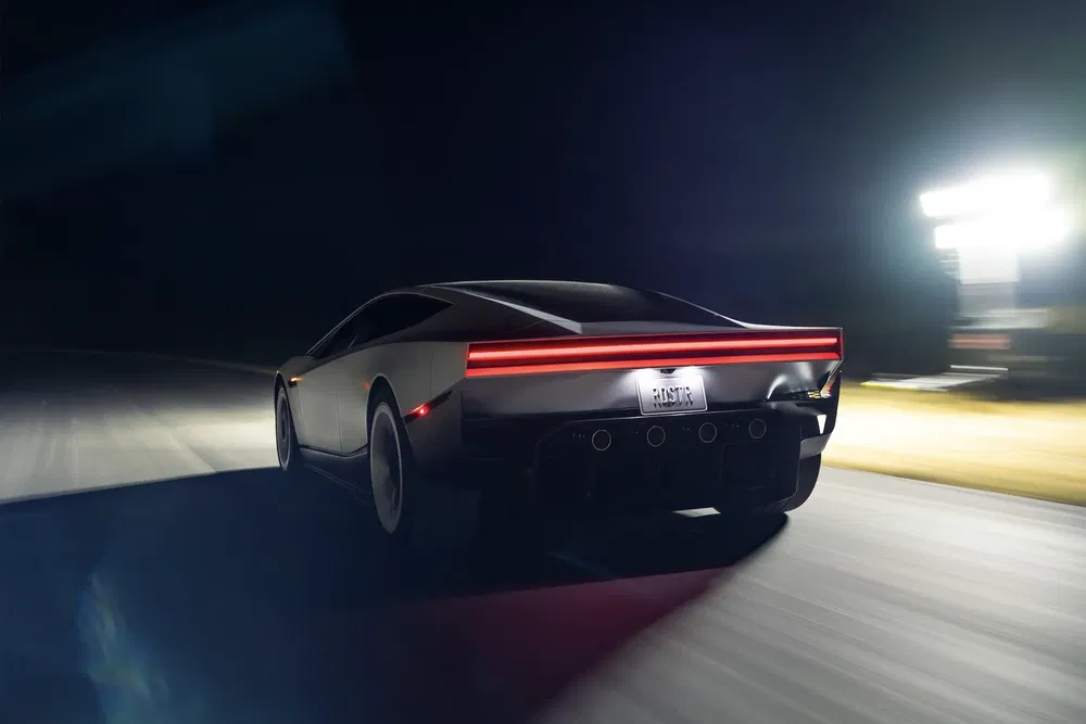 Voiture de sport électrique Tesla Roadster 2023 roulant rapidement sur une piste de nuit.
