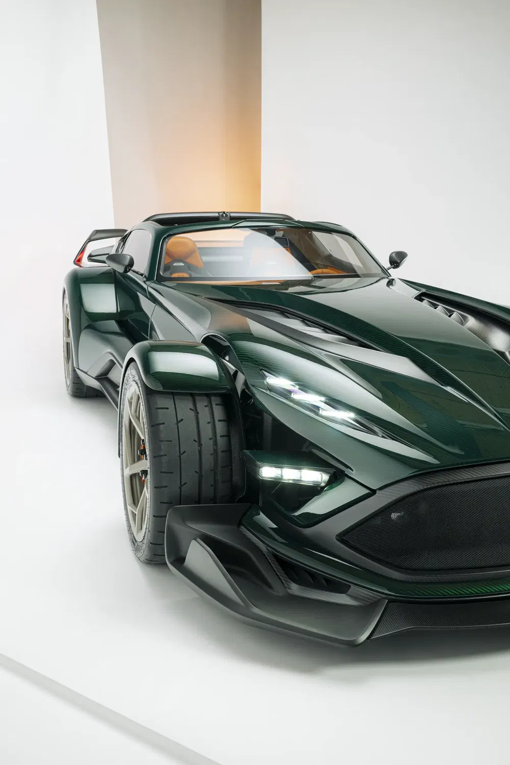 Voiture de sport verte avec intérieur orange et design aérodynamique moderne, exposée en studio.