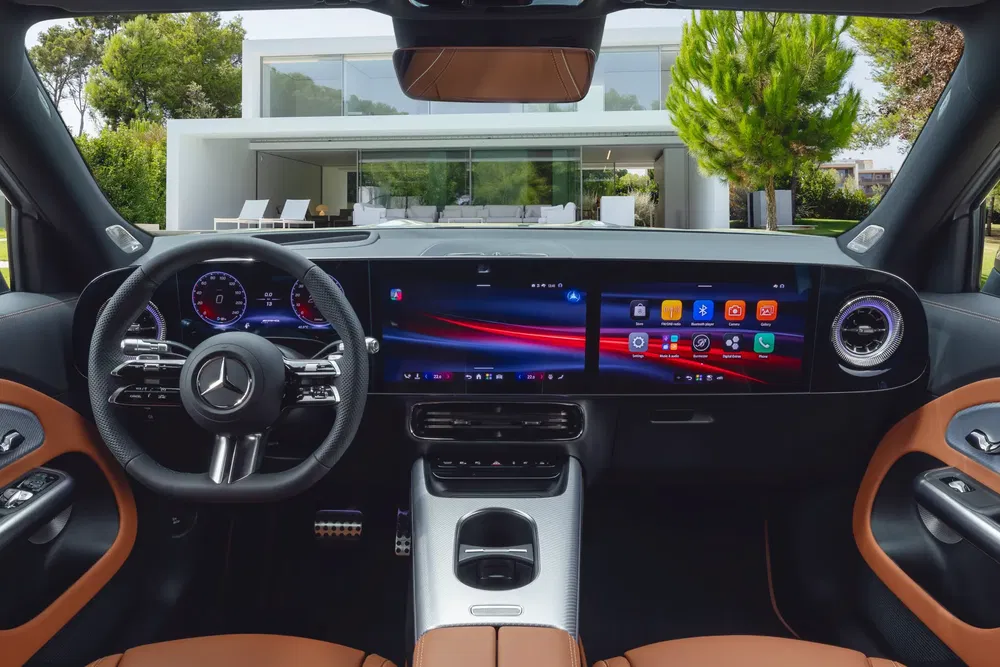 Modern interieur van een Mercedes met touchscreen, tegenover een eigentijds huis.