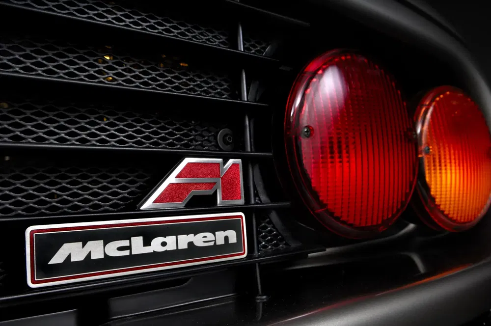 Sigle McLaren F1 sur calandre avec feux arrière rouges luisants.