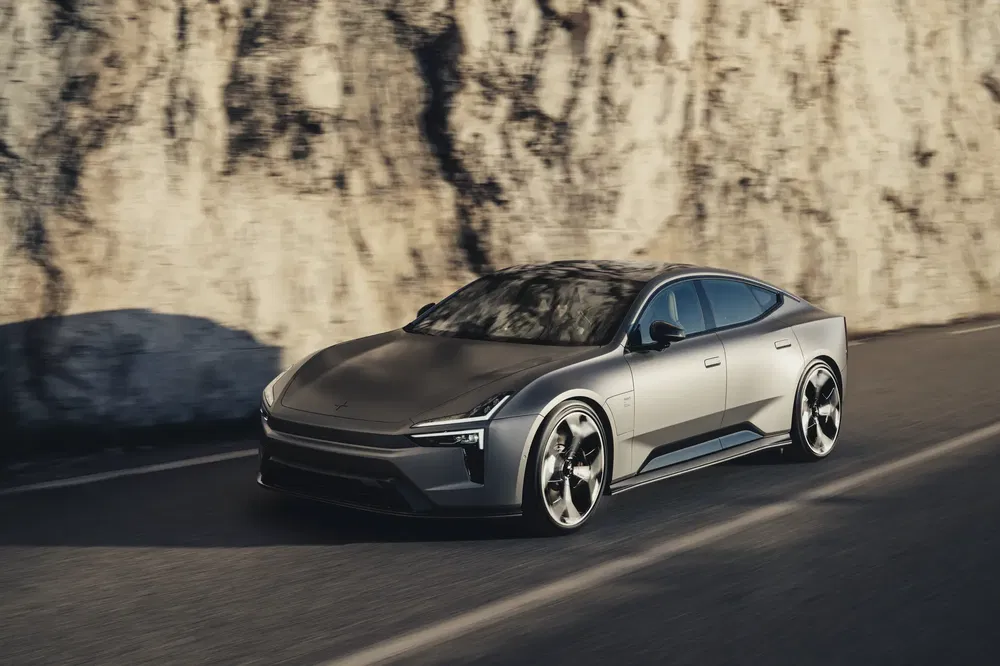 Luxe elektrische Polestar 5 auto op een bochtige weg naast een klif.