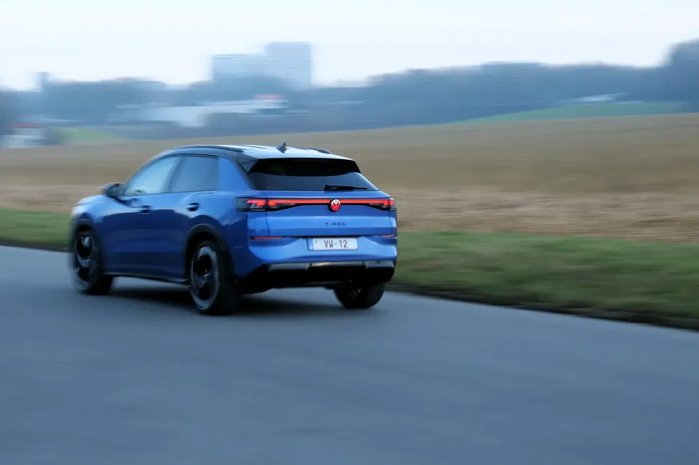 Blauwe Volkswagen ID.4 SUV rijdt op een rustige landelijke weg.