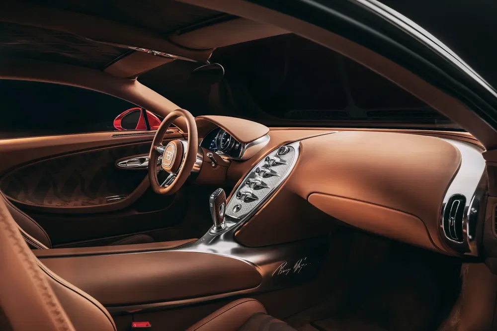 Intérieur luxueux en cuir brun d'une Bugatti Chiron, avec volant et tableau de bord élégants.