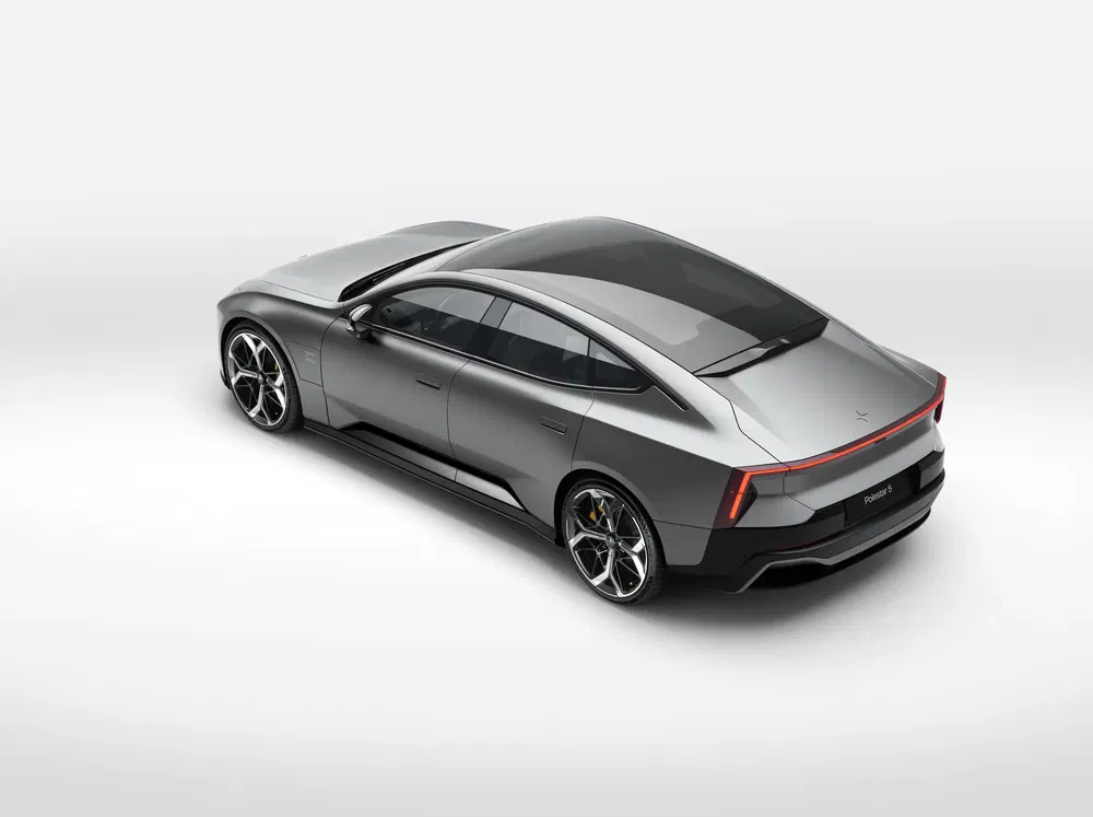 Grijze Polestar 5 sportauto met aerodynamisch design en panoramisch dak, achteraanzicht.