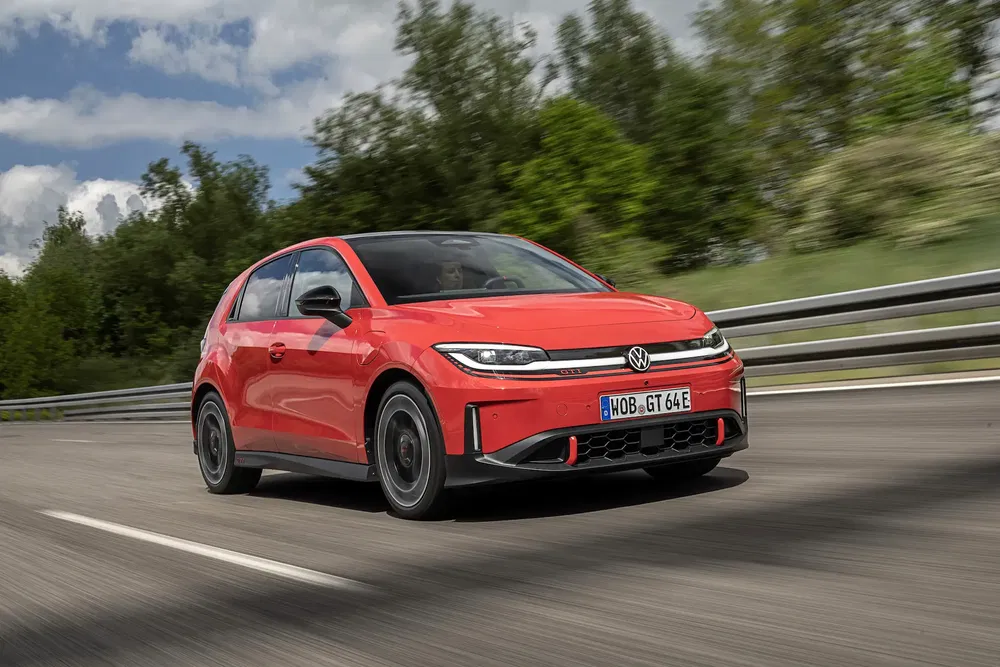 Rode Volkswagen ID.GTI op een weg, omgeven door groene achtergrond.