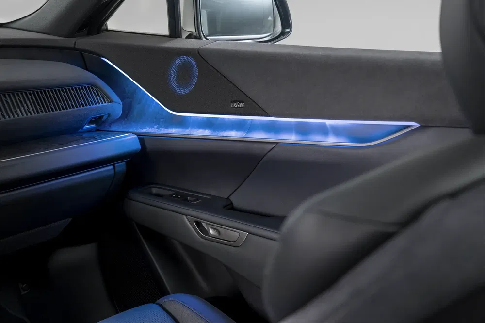 Intérieur d'une voiture avec éclairage d'ambiance bleu et haut-parleur intégré sur la porte.