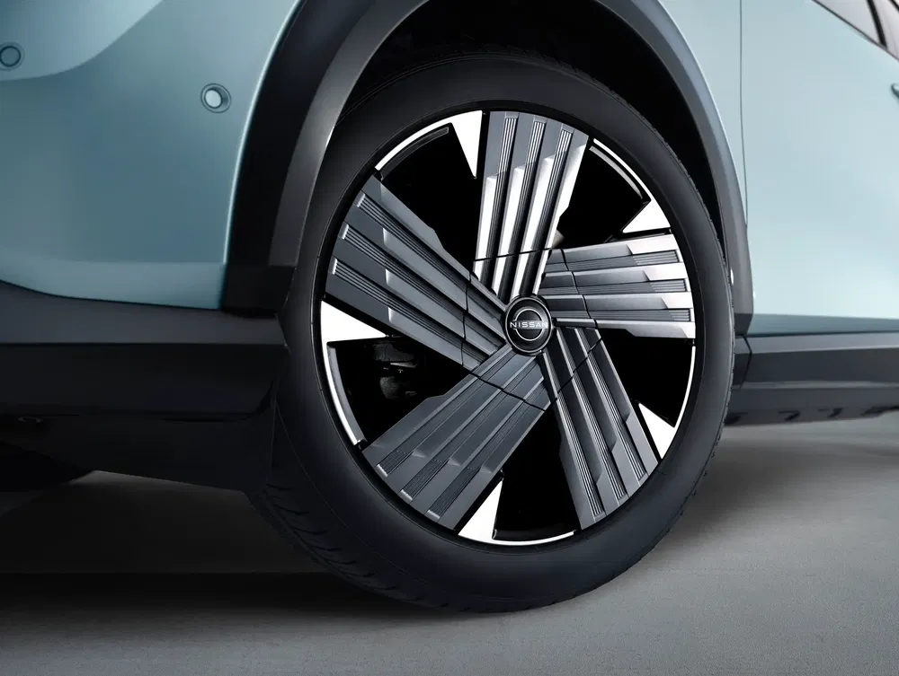Jante de voiture Nissan au design moderne sur une carrosserie bleu clair.