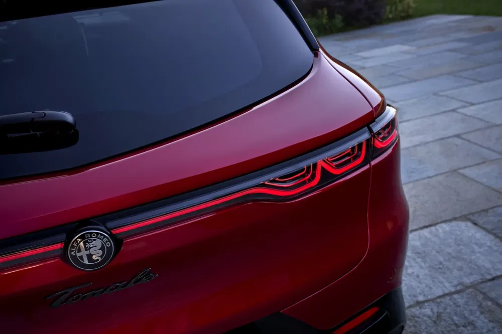 Achteraanzicht van een rode Alfa Romeo Tonale met opvallende moderne achterlichten.