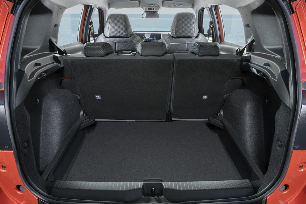 Coffre spacieux d'un SUV compact orange avec sièges arrière rabattus, vue intérieure.