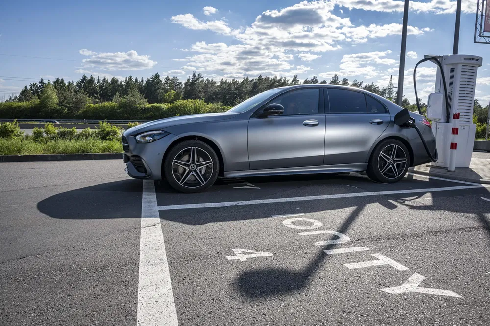 Voiture Mercedes chargée sur une station Ionity sous un ciel dégagé.