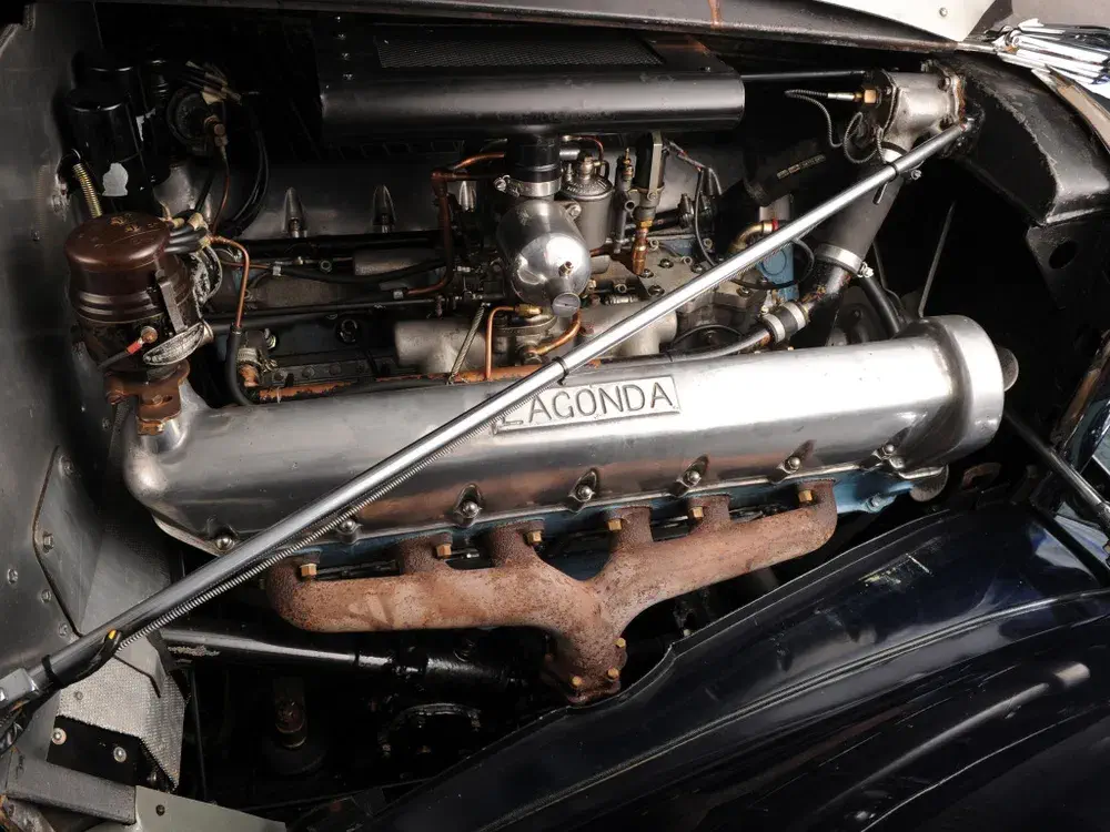Moteur Lagonda classique dans une voiture vintage, détails mécaniques visibles et composants d'époque.
