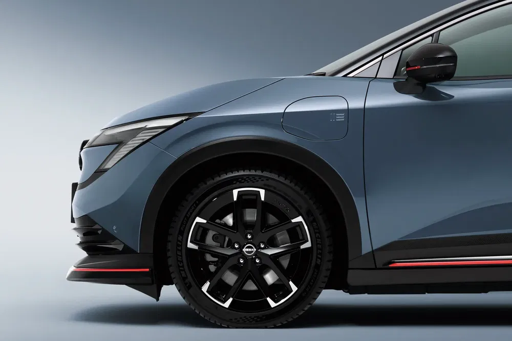Vue latérale de la Nissan électrique moderne avec des jantes noires élégantes.