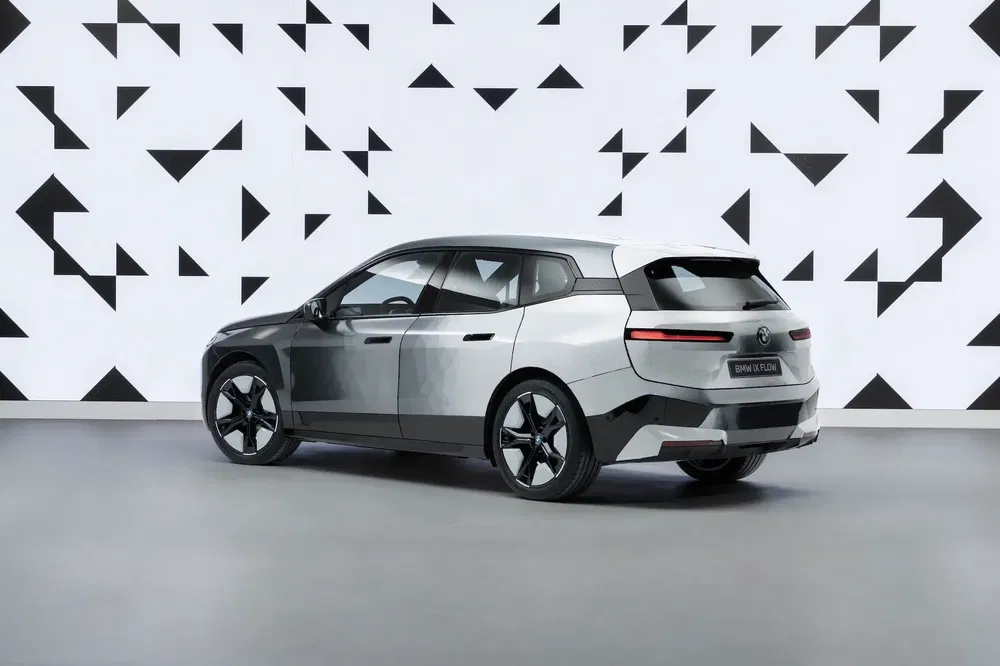 {"fr":"BMW iX Flow SUV gris avec motif variable, arrière gauche, fond géométrique noir et blanc.","nl":"BMW iX Flow SUV grijs met veranderlijk patroon, linkerachterzijde, geometrische zwart-wit achtergrond."}