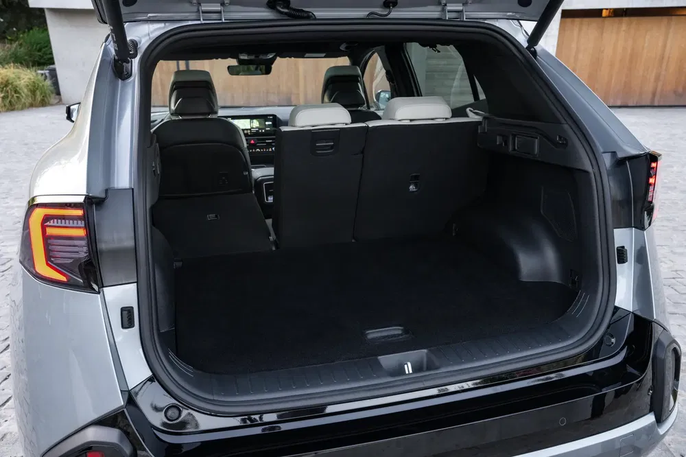 Coffre spacieux d'un Kia EV9 avec sièges arrière rabattables et intérieur moderne.