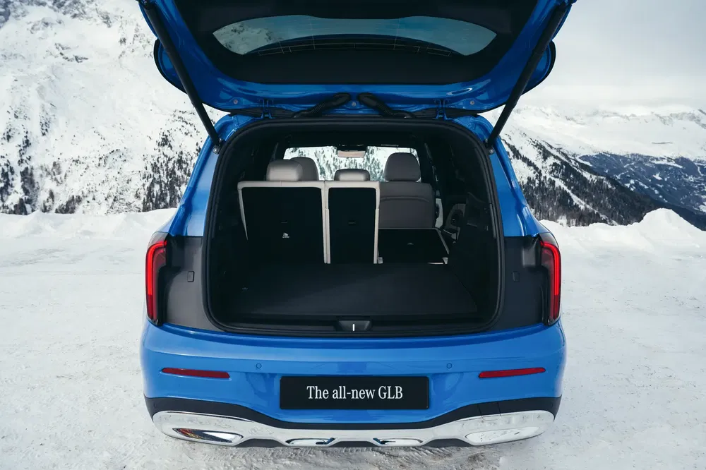Mercedes-Benz GLB sur neige, coffre spacieux ouvert dévoilant sièges arrières rabattables.