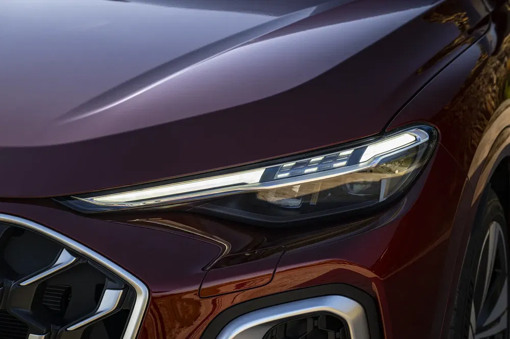 Phare avant d'une Audi Q5 avec design moderne et ligne élégante couleur bordeaux.