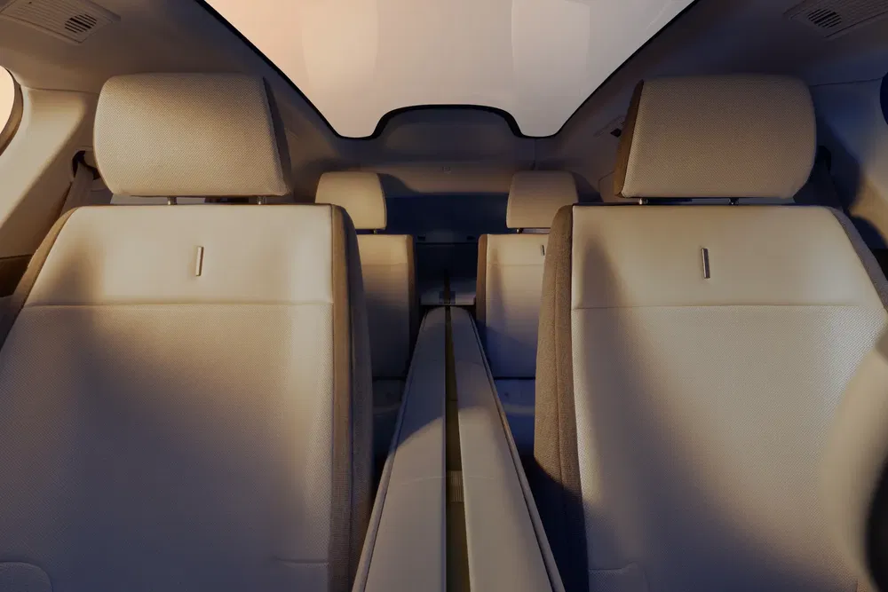 Ruime interieur van de Tesla Model X met lichte leren stoelen en panoramisch dak.