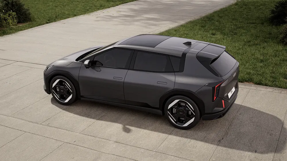 SUV électrique Kia EV6 gris sur une allée, design moderne et jantes noires distinctives.